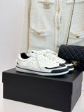 White low-top sneakers with black side panels and white laces
