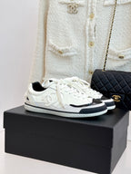 White low-top sneakers with black side panels and white laces
