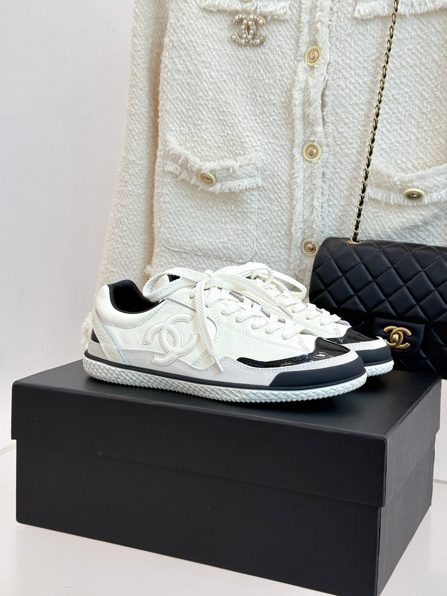 White low-top sneakers with black side panels and white laces
