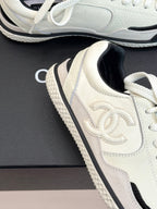 Close-up white low-top sneaker with embossed logo, black-trimmed edge, and lace-up