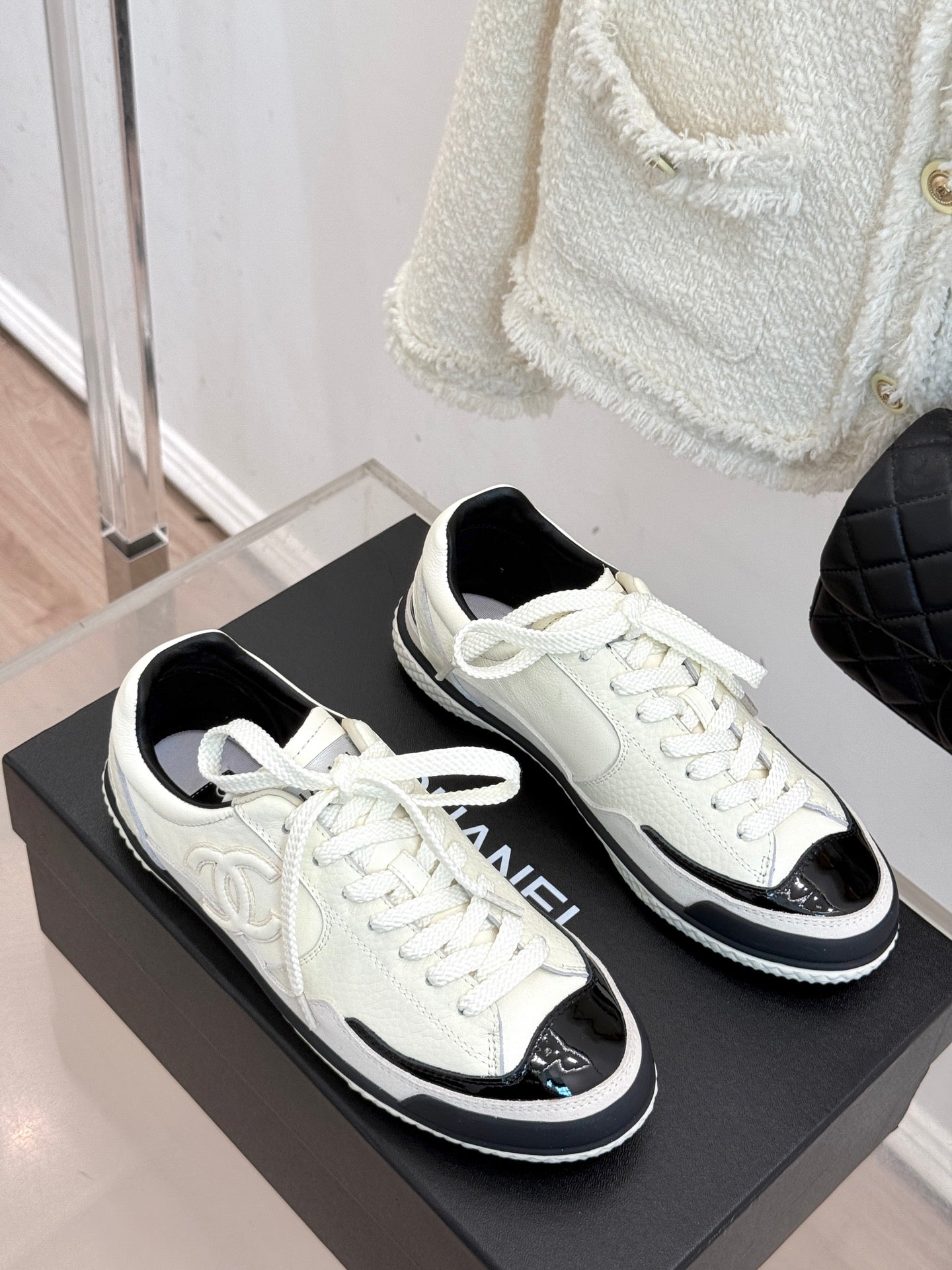 Pair of white low-top sneakers with black toe caps and white laces