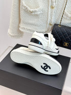 White low-top sneakers with black sockliners and textured tread soles