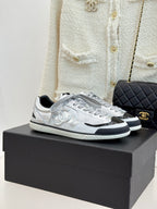 Chanel low-top sneakers in metallic silver with black-trim sole and lace-up front
