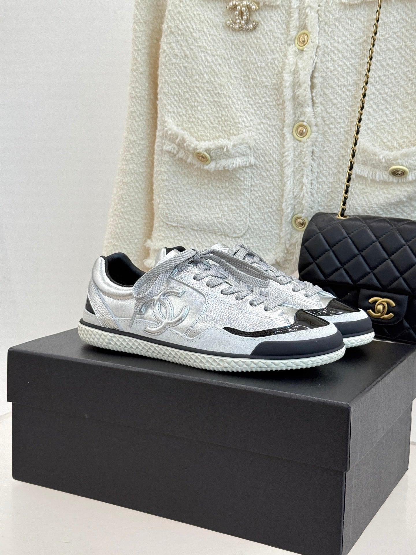 Chanel low-top sneakers in metallic silver with black-trim sole and lace-up front