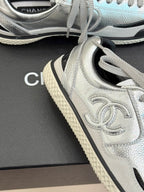 Close-up of metallic silver sneaker side panel with the Chanel logo and lace-up details