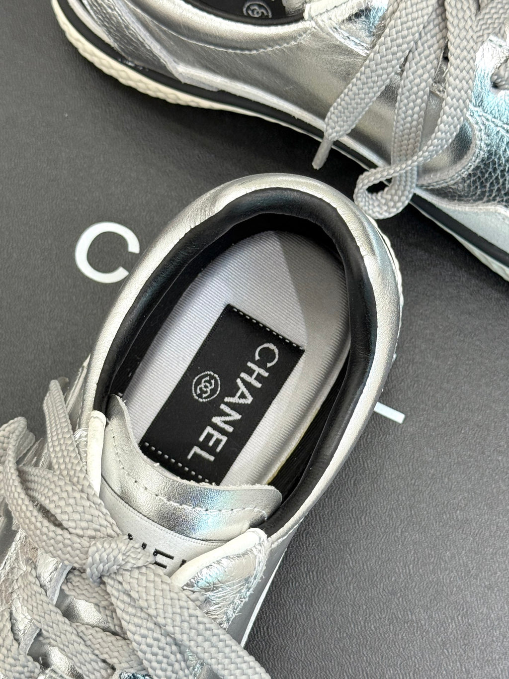 Close-up of sneaker tongue label reading CHANEL on the inner collar