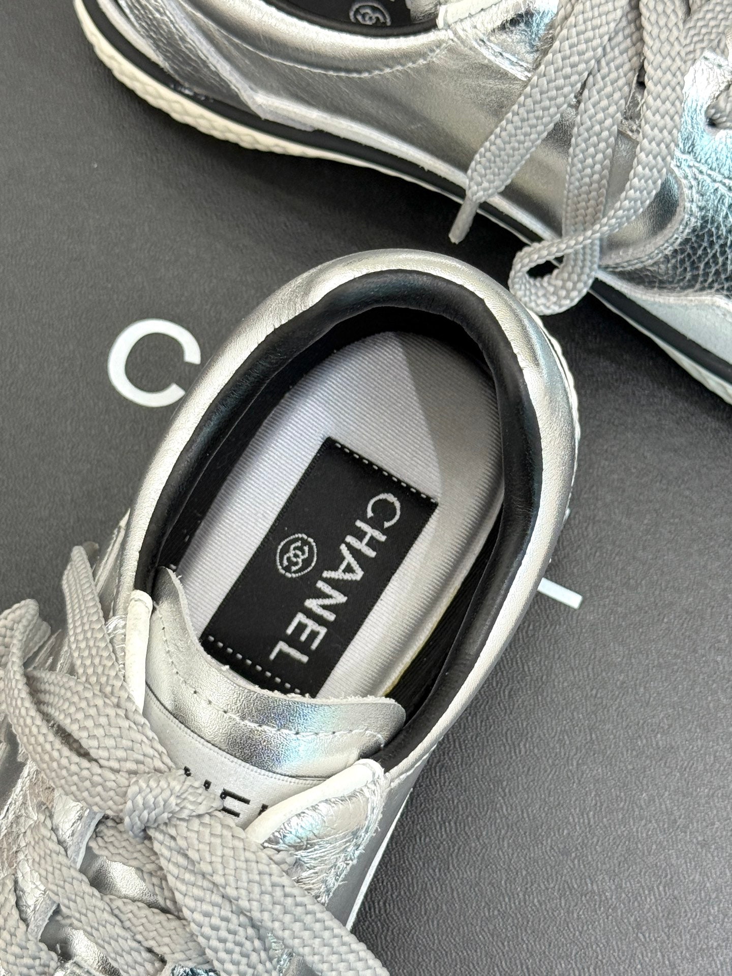 Close-up of sneaker tongue label reading CHANEL on the inner collar