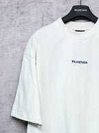 White crew-neck T-shirt with BALENCIAGA chest logo, short sleeves.