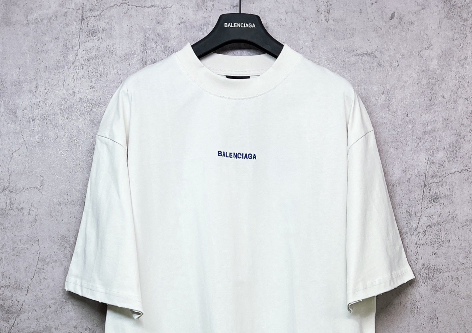 White crew-neck T-shirt with small BALENCIAGA chest print, short sleeves.