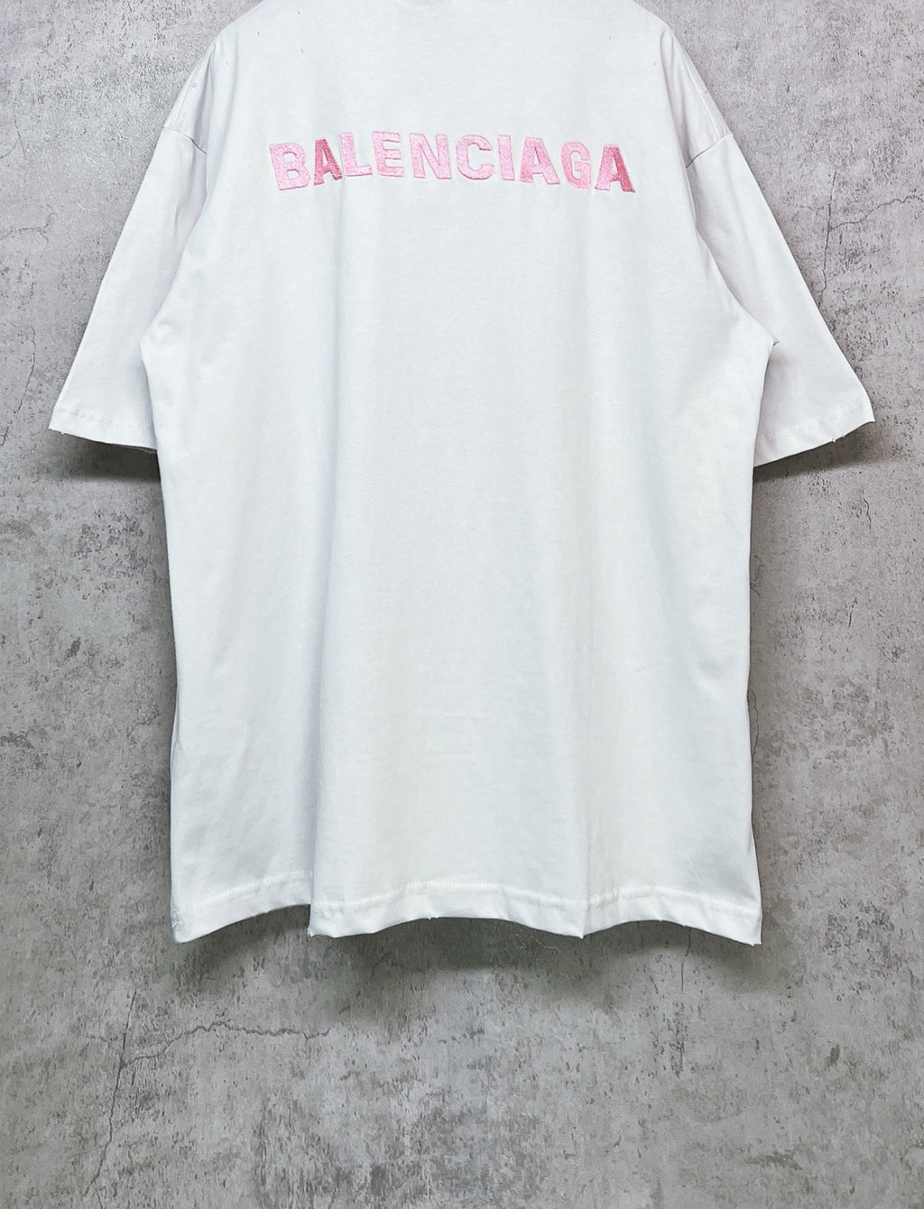 White short-sleeve crewneck T-shirt with pink BALENCIAGA logo on upper back