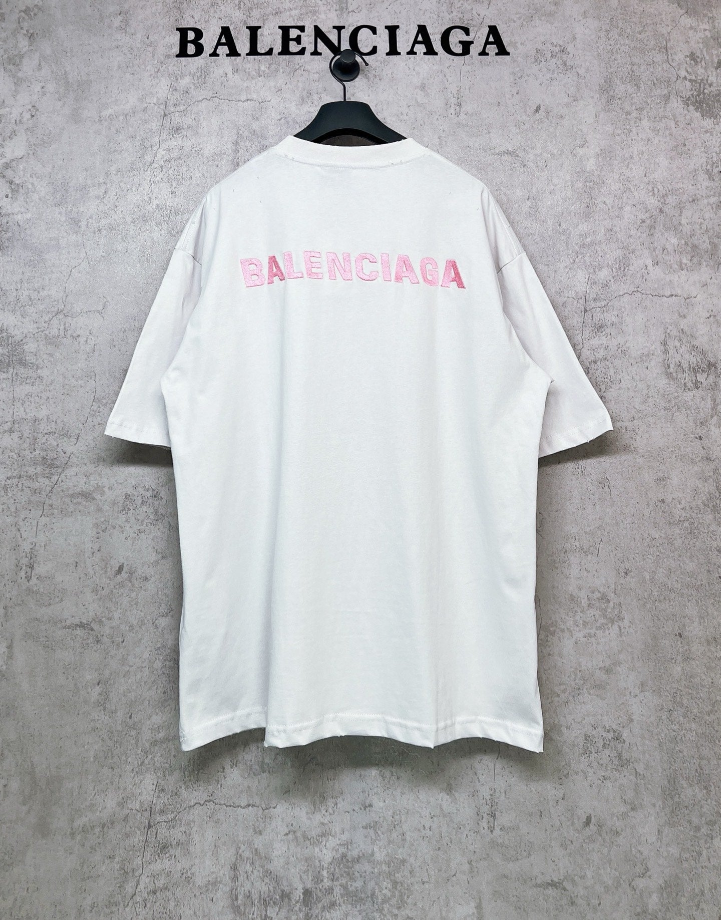 White short-sleeve crewneck T-shirt with pink BALENCIAGA logo on back