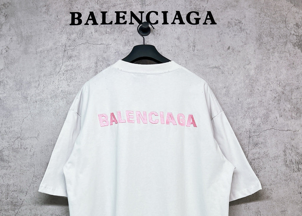White short-sleeve crewneck T-shirt with pink BALENCIAGA logo on back