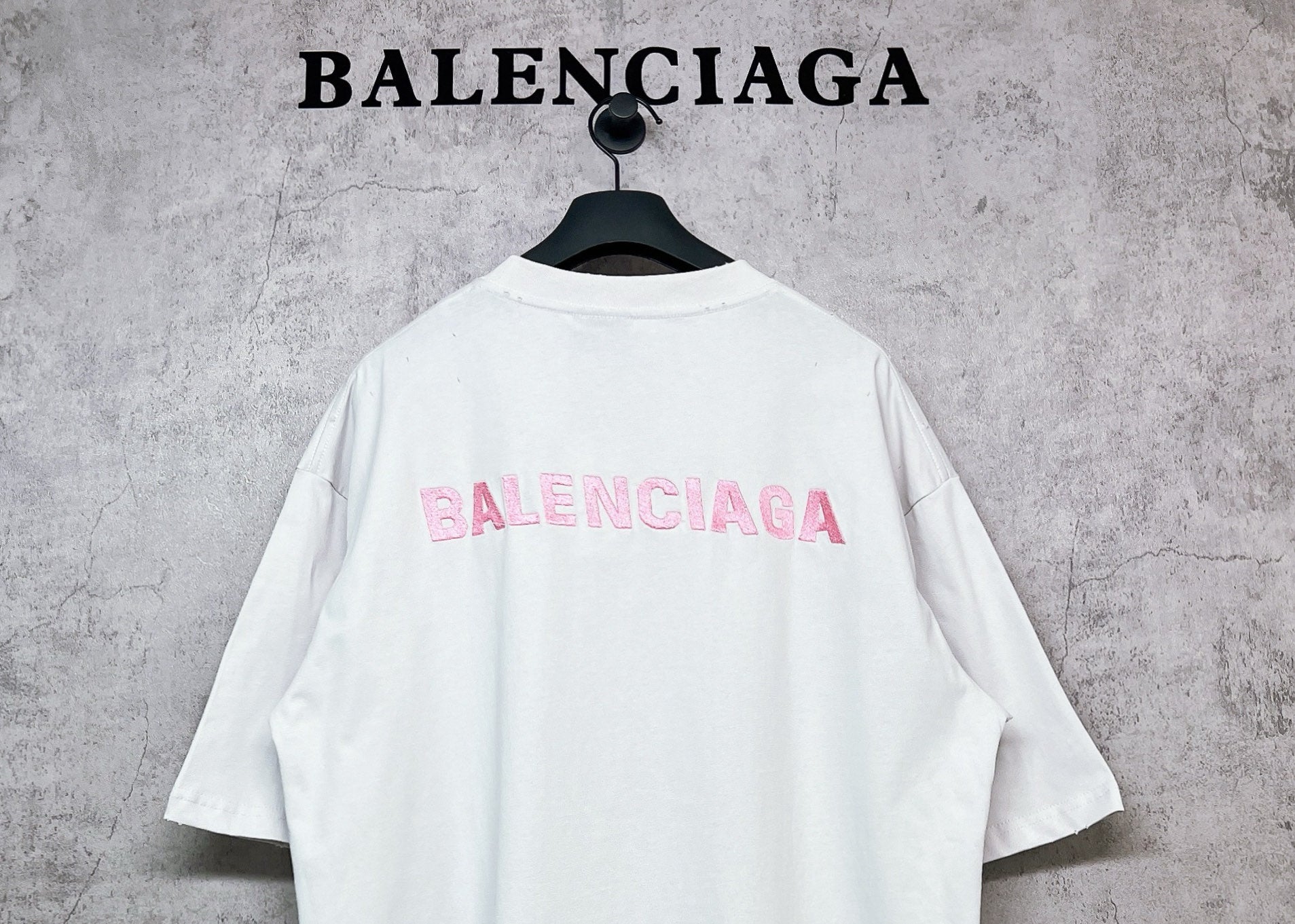 White short-sleeve crewneck T-shirt with pink BALENCIAGA logo on back