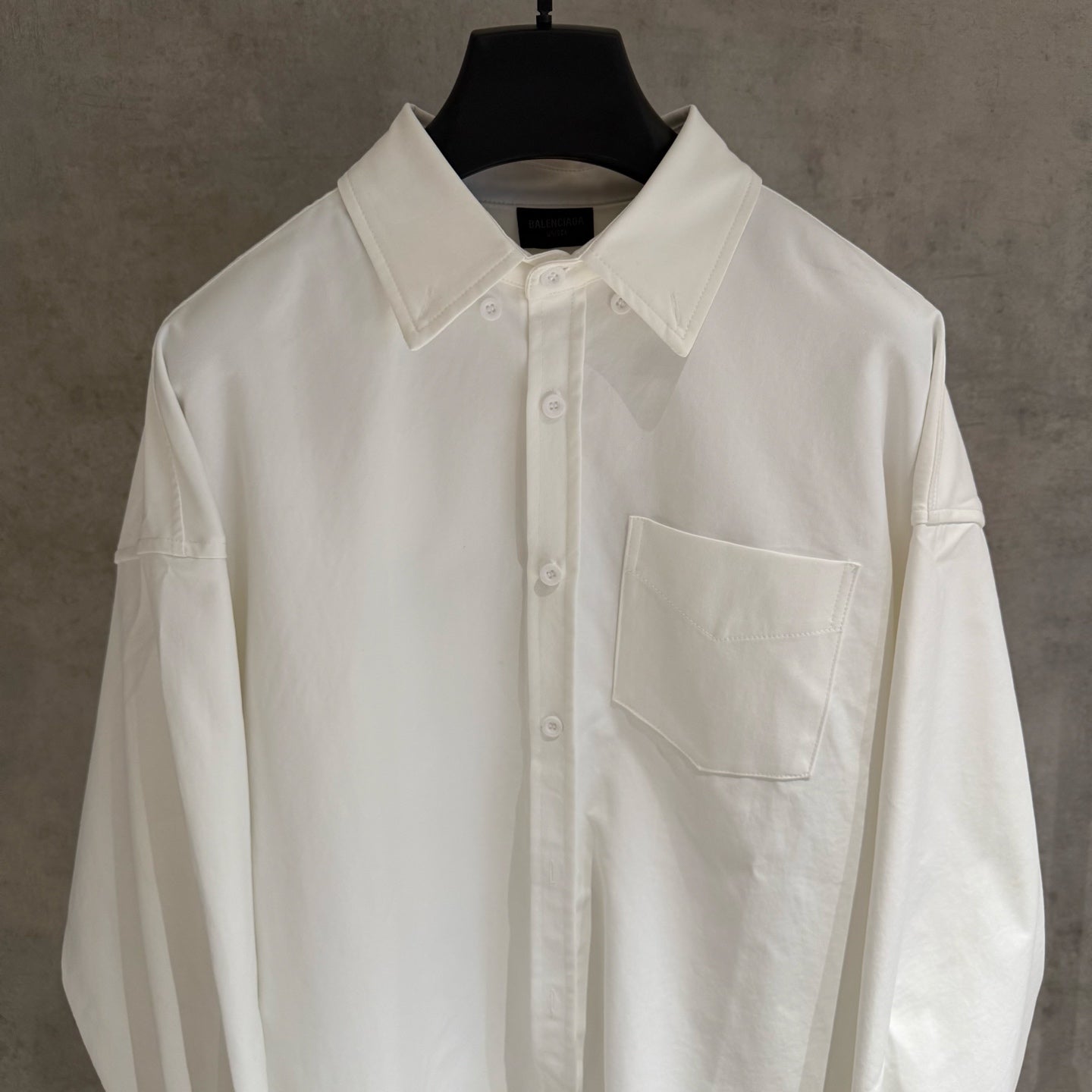 White button-up shirt with pointed collar, front placket, chest pocket