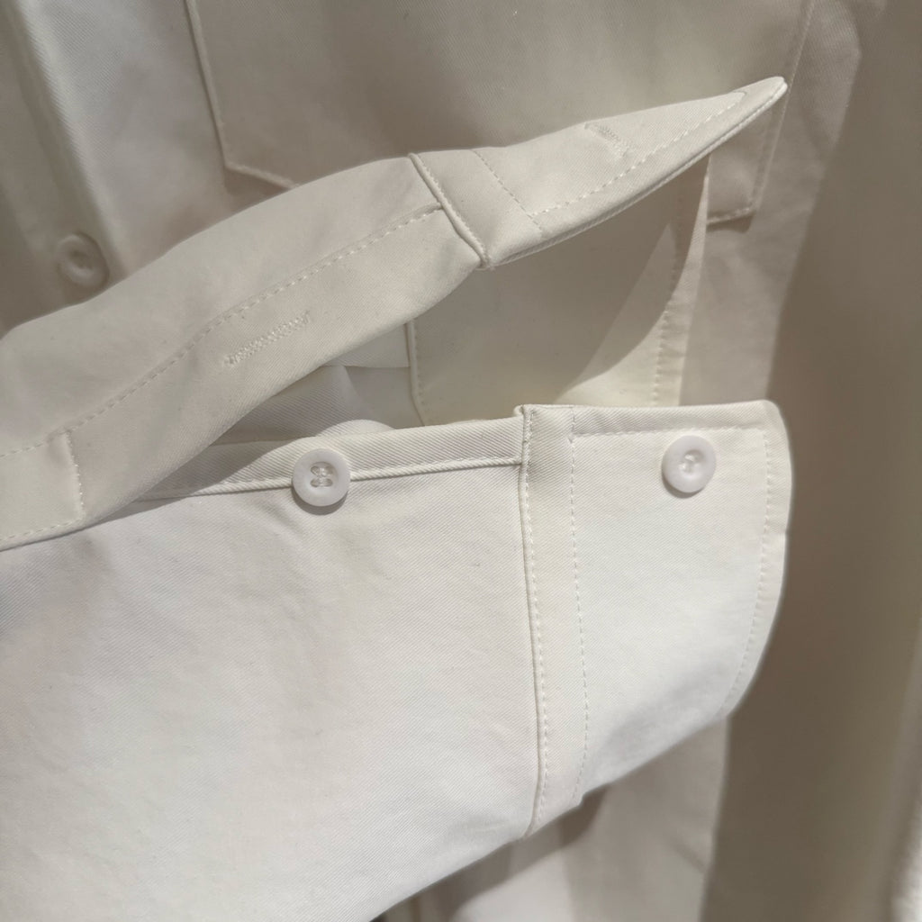 White long-sleeve shirt with buttoned cuff and side seam detail