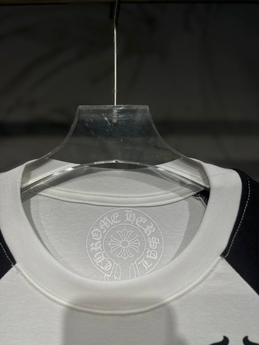 White raglan T-shirt neckline with faint circular logo