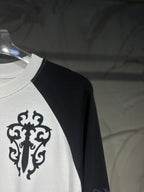 White raglan shirt with black sleeve, large ornamental cross graphic