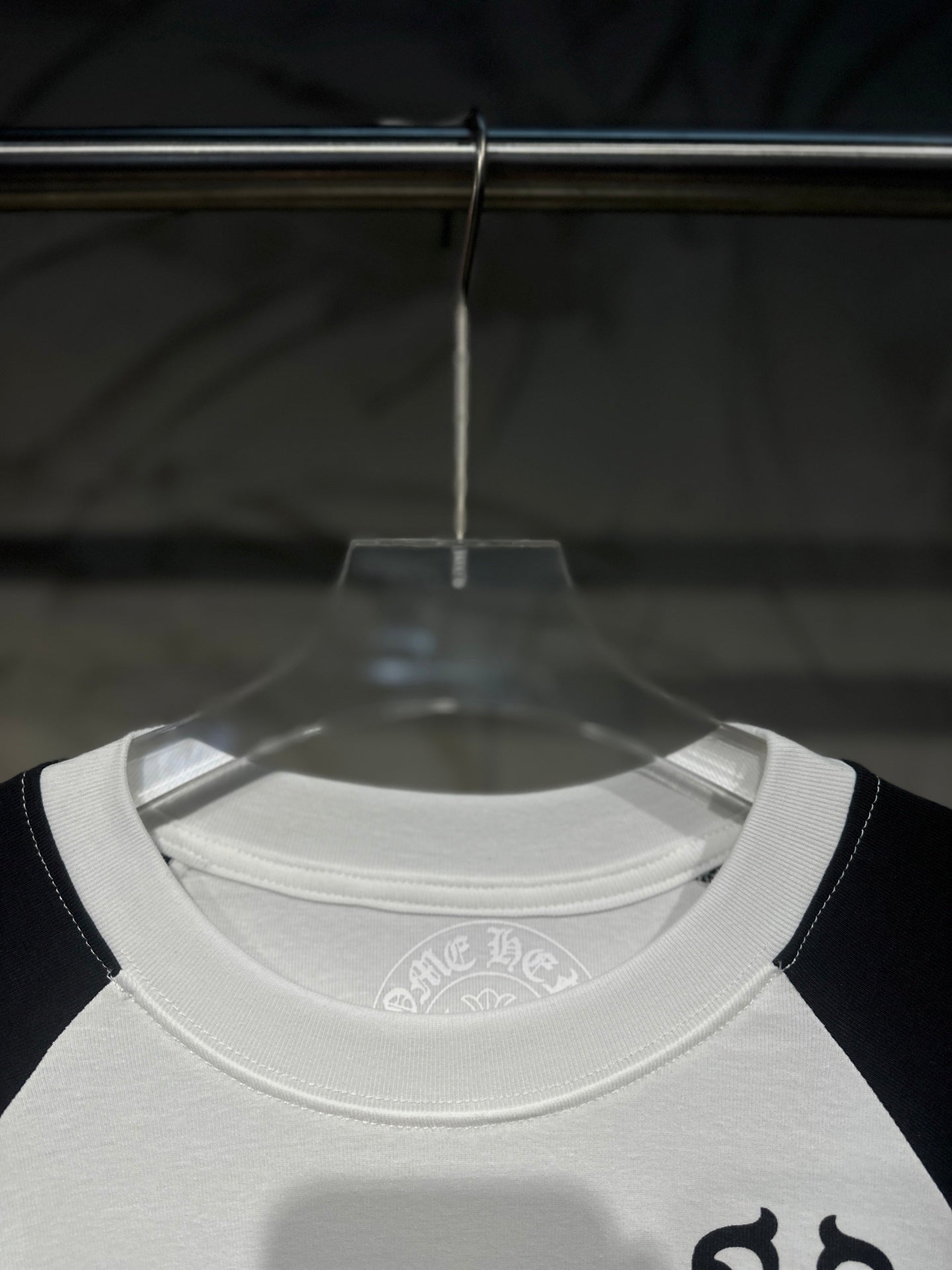 White raglan long-sleeve T-shirt collar with small circular logo at neckline