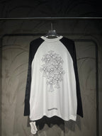 White raglan long-sleeve shirt with black sleeves, floral cross graphic back