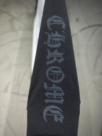 Black sleeve panel with vertical blue-gray text emblem on raglan shirt