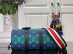 Blue monogram satchel with red-white-blue stripe strap and gold-tone side hardware
