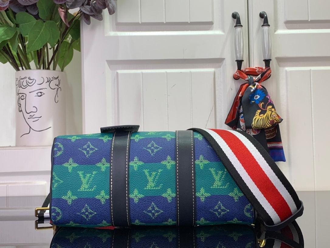 Blue monogram satchel with red-white-blue stripe strap and gold-tone side hardware