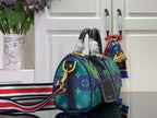 Blue monogram handbag with gold-tone hardware, top handles, and red-white-blue shoulder strap