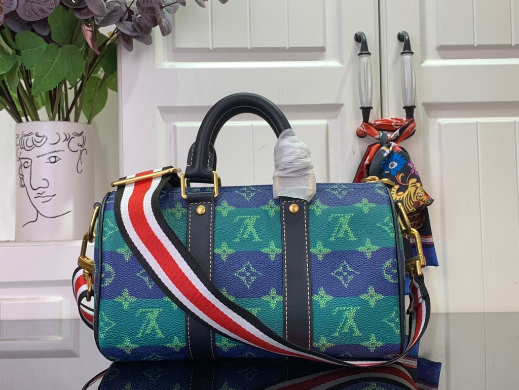 Louis Vuitton blue patterned bag with black leather trim and diagonal striped shoulder strap