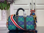Blue monogram handbag with stripe side strap, dark center panel, and gold-tone handles