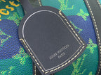 Rounded dark leather patch with “Louis Vuitton Paris” text on blue-green monogram bag