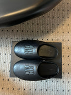 Balenciaga logo slide sandals, side view with footbed openings and logos