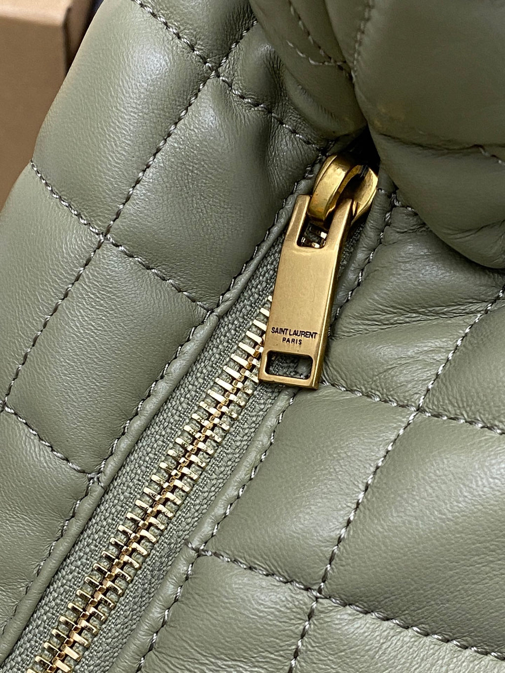 Sage green quilted hobo bag zipper pull with Saint Laurent label