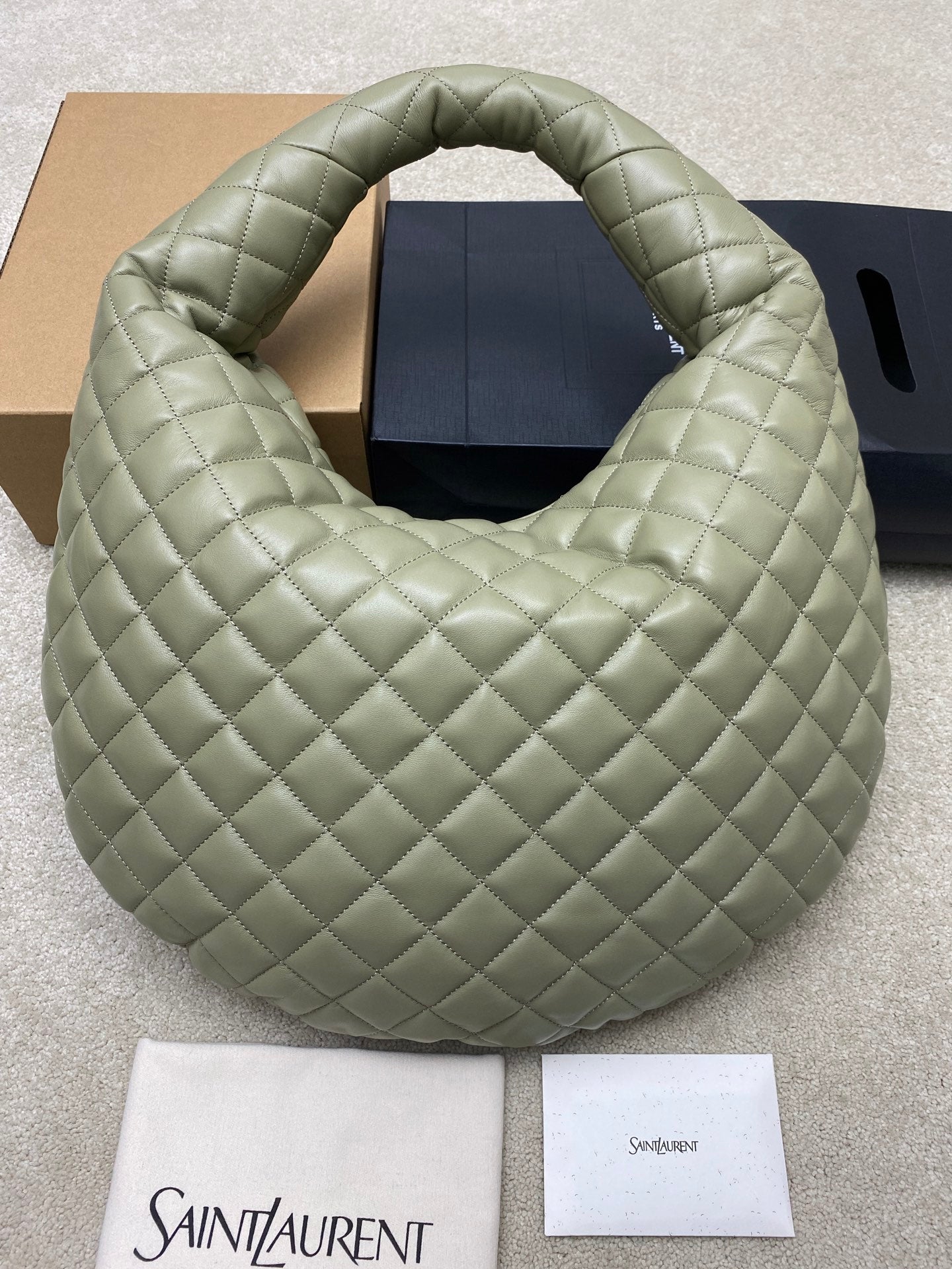 Sage green quilted hobo bag with wide top opening and gold logo