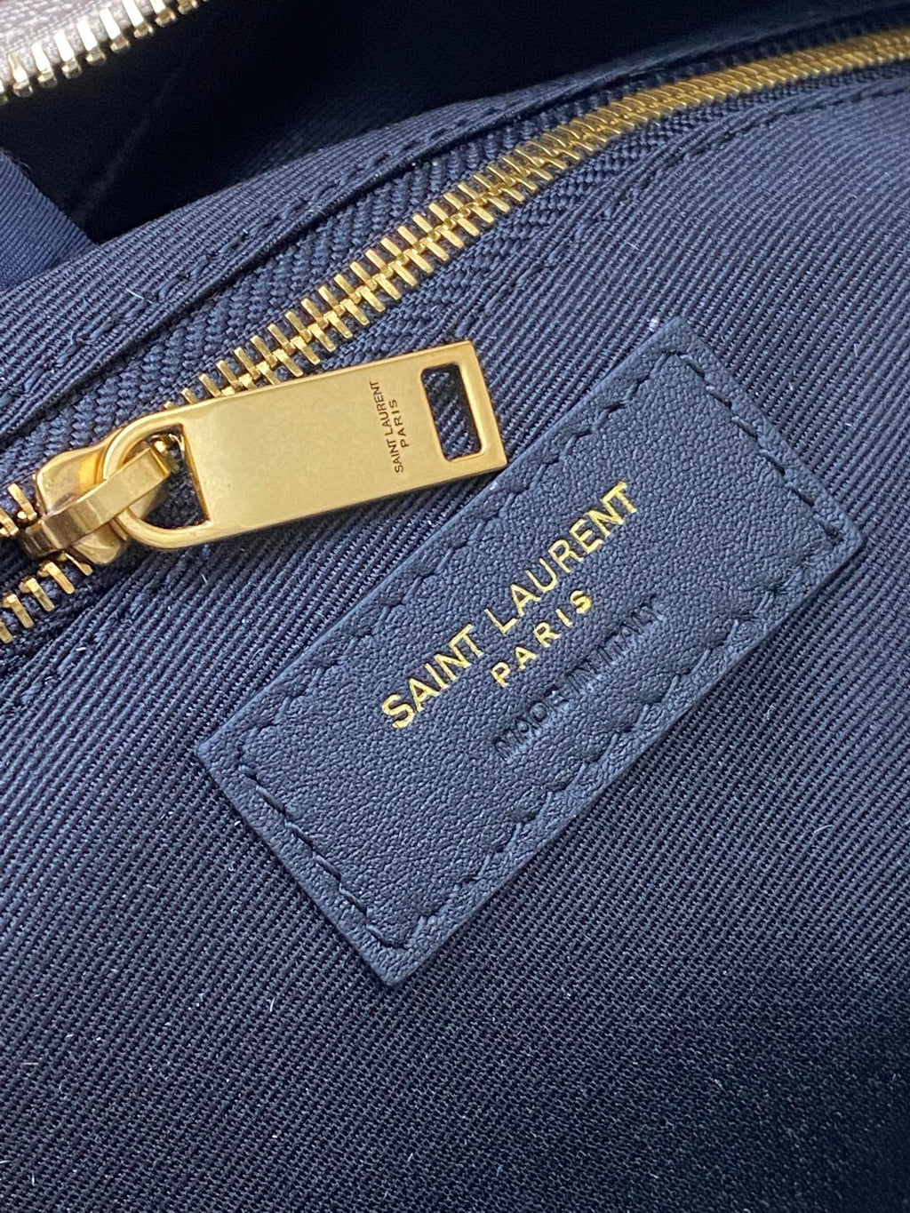 Navy fabric interior pocket with SAINT LAURENT PARIS logo label and gold zipper
