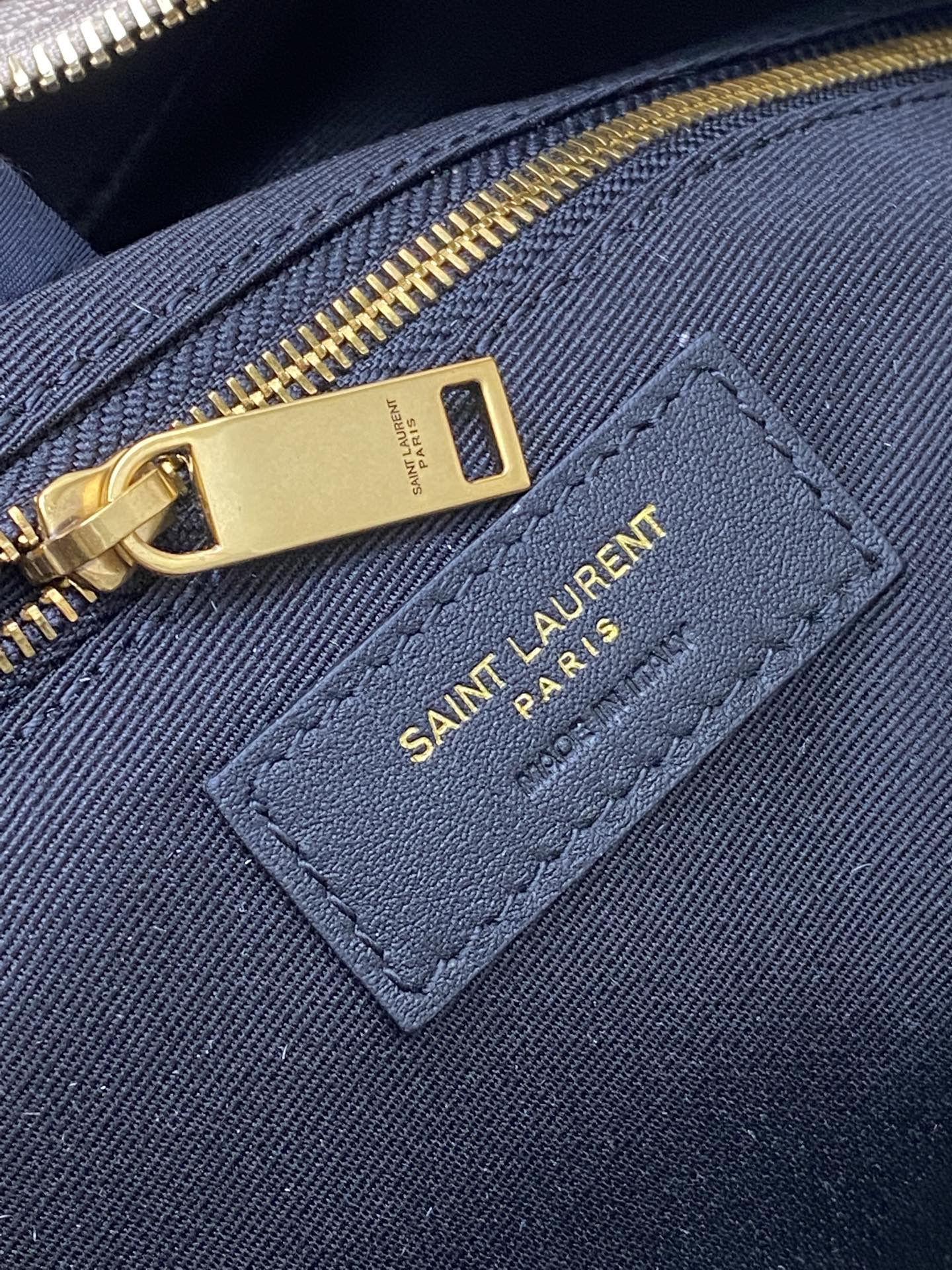 Navy fabric interior pocket with gold zipper and Saint Laurent PARIS label