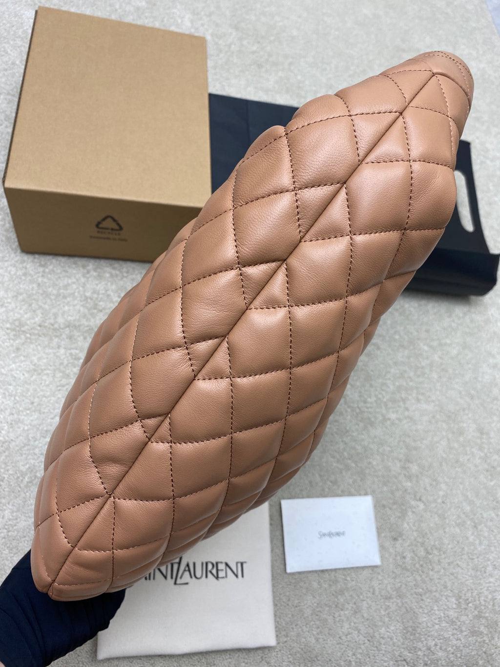 Quilted hobo bag side profile, tan leather with stitched diamond pattern and padded handle
