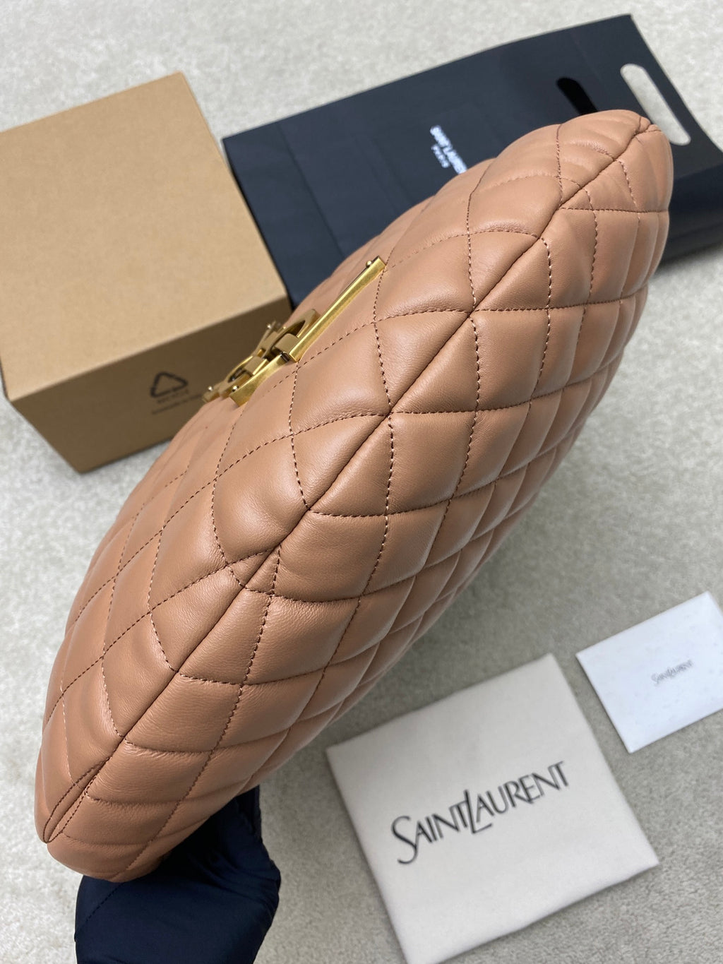 Quilted hobo bag with gold zipper and hardware, tan leather, angled side view
