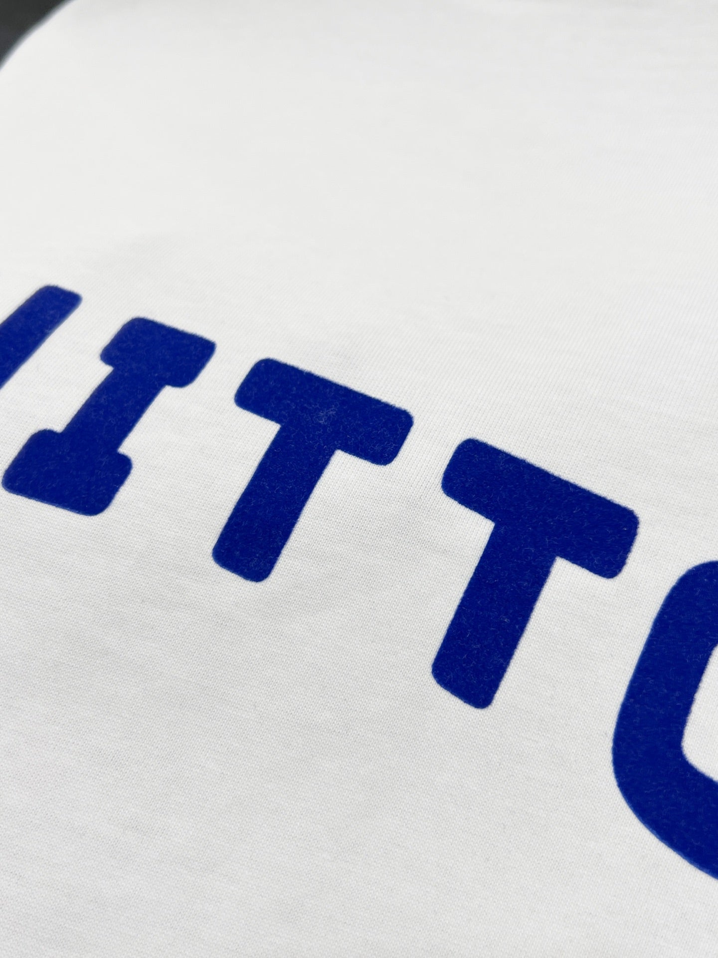 White T-shirt fabric with blue 'VUITTON' lettering detail