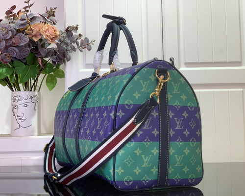 Men's duffel bag with multicolor monogram print, striped shoulder strap and gold hardware