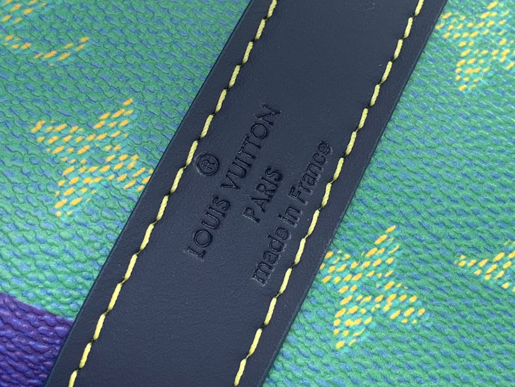 Leather interior patch with "Louis Vuitton Paris" text on multicolor duffel