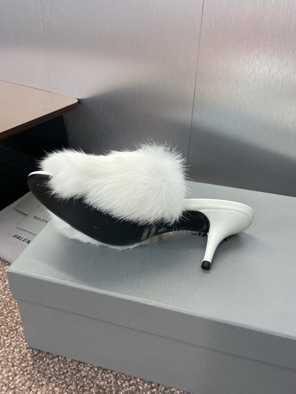 White faux-fur slide mule with slim stiletto heel, side profile.