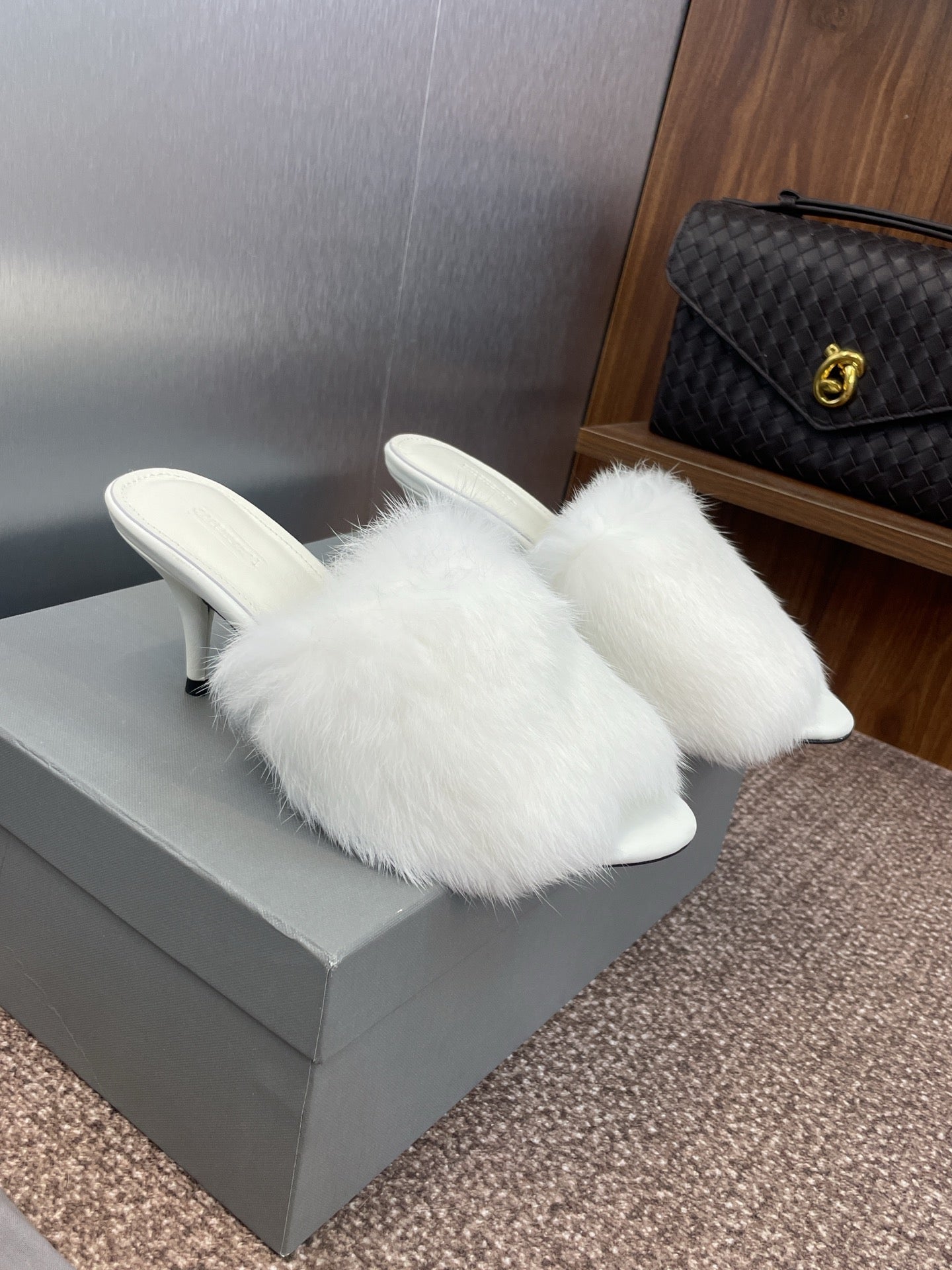 White faux-fur mules with slim stiletto heel and cushioned footbed.