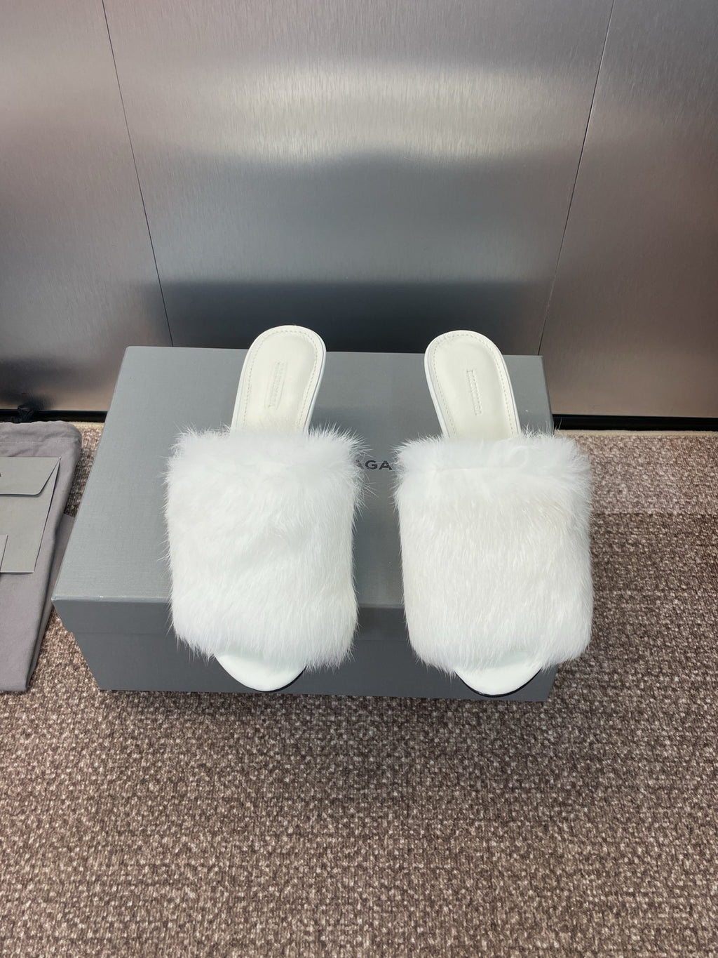 White faux-fur slide sandals with slim stiletto heel, open toe.