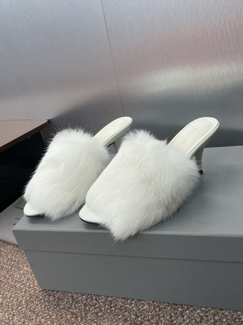 Pair of white faux-fur mules with slim stiletto heel, open toe.