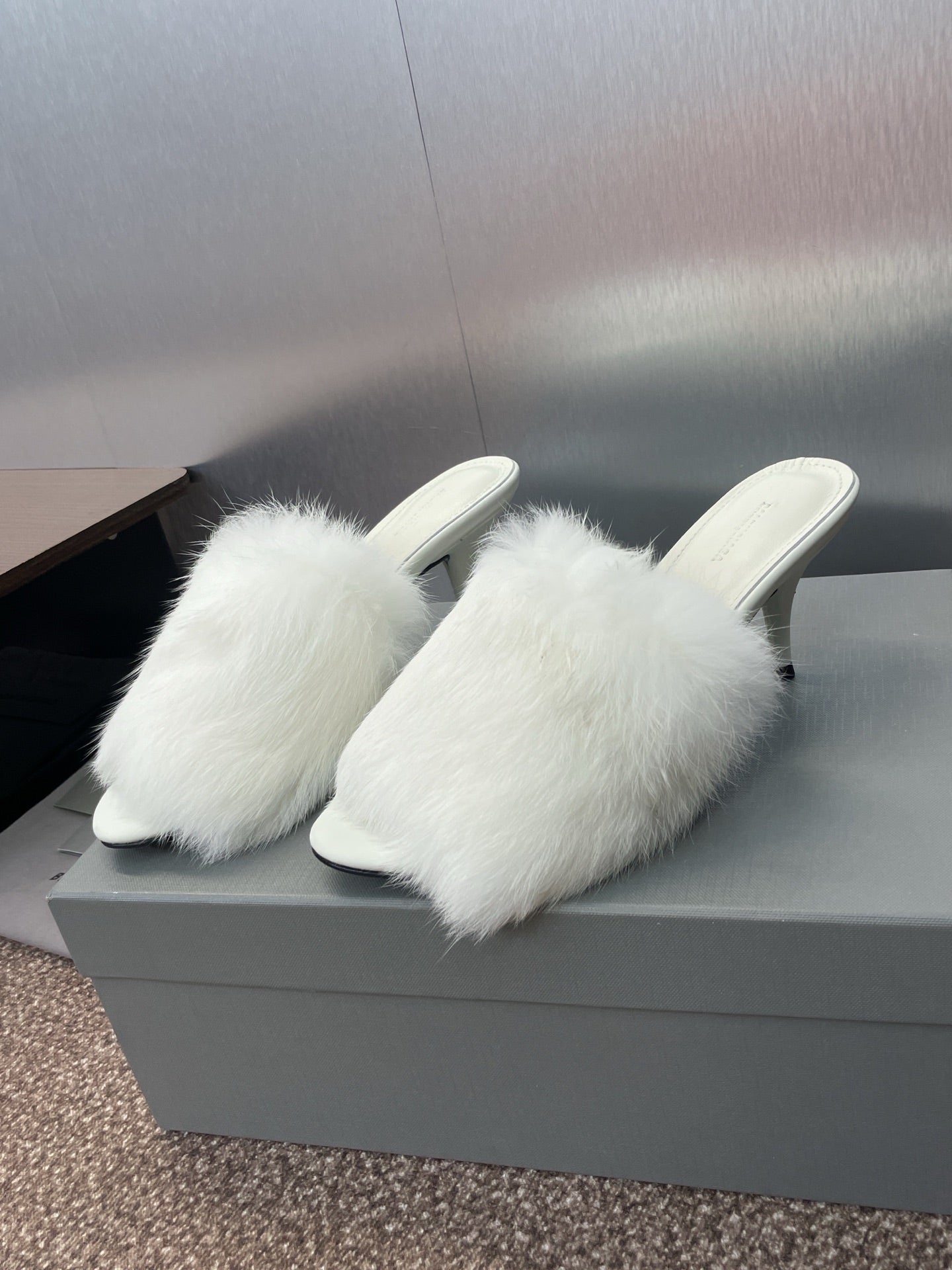 Pair of white faux-fur mules with slim stiletto heel, open toe.