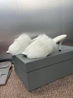 White faux-fur mules with slim stiletto heel and open-toe design.