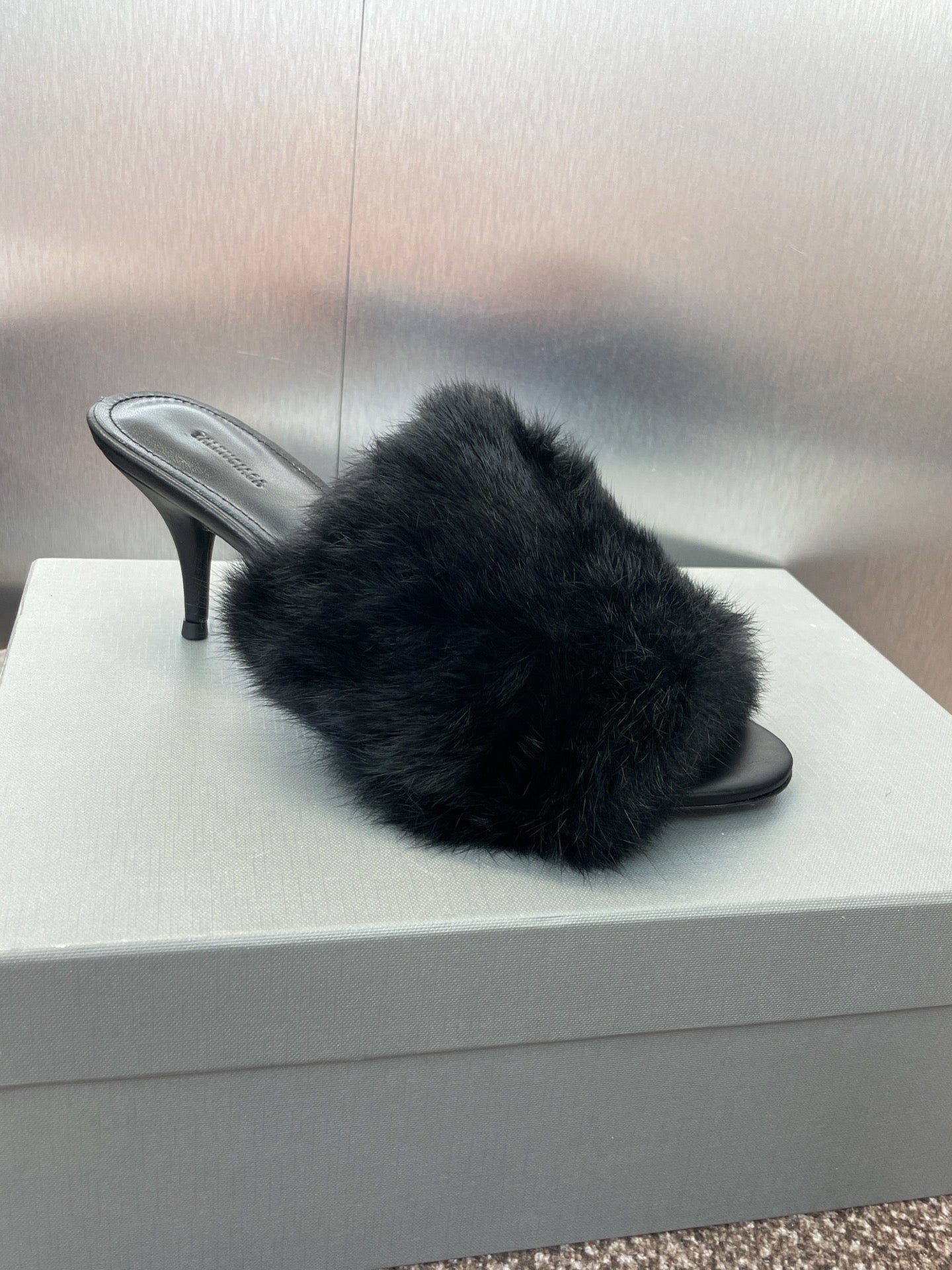 Black faux-fur slide sandal with open toe and slender heel.