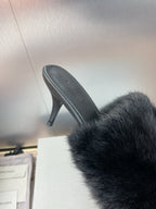 Black faux-fur slide sandal showing side view and stiletto heel.