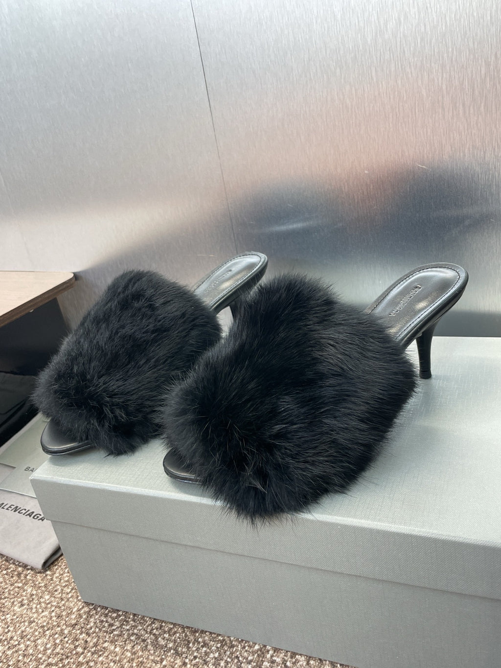 Black faux-fur slide sandals with open toe and slim stiletto heel.