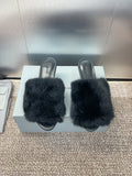 Black faux-fur slide sandals with open toe and curved platform heel.